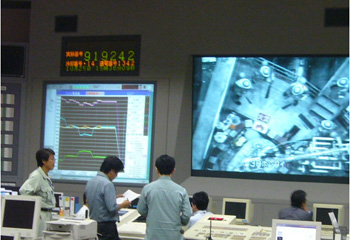 photo:制御室スクリーンで確認しながら消火活動を指揮する実験責任者