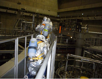 photo:空気呼吸器を着用し炭酸ガス消火器を持って出火場所に向かう班員