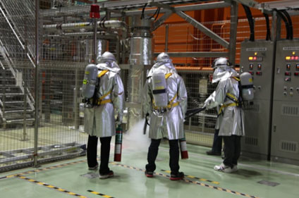 炭酸ガス消火器による初期消火活動を行う自衛消防隊隊員